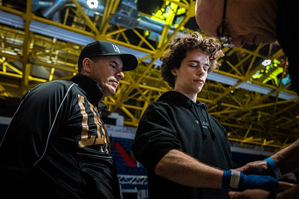 Un entraîneur enroule les mains d'un combattant avant son combat au FTC 13