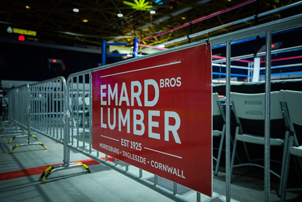 Bannière Emard Bros Lumber sur les barrières autour du ring au Cornwall Civic Center, FTC 13