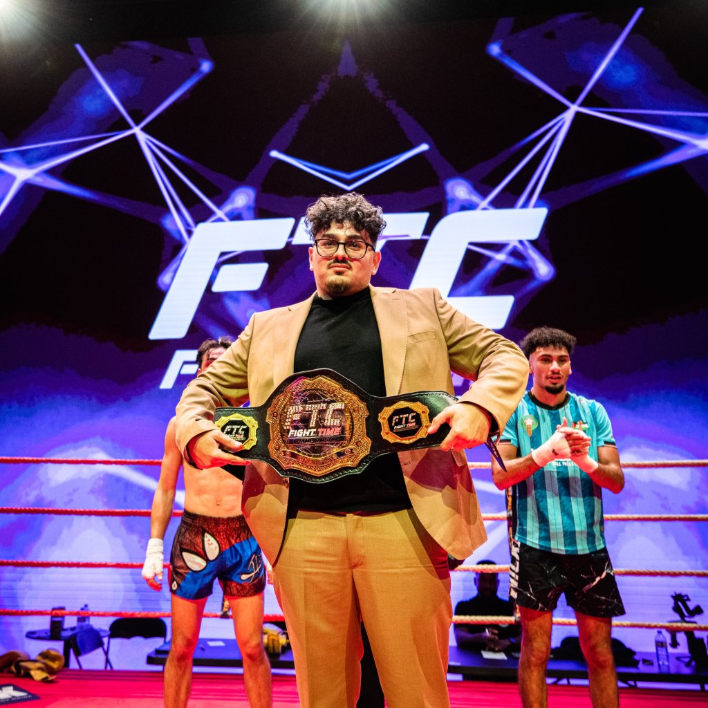 Younes Chahti, fondateur et CEO de FTC, tenant la ceinture de champion FTC dans le ring devant l'écran géant FTC
